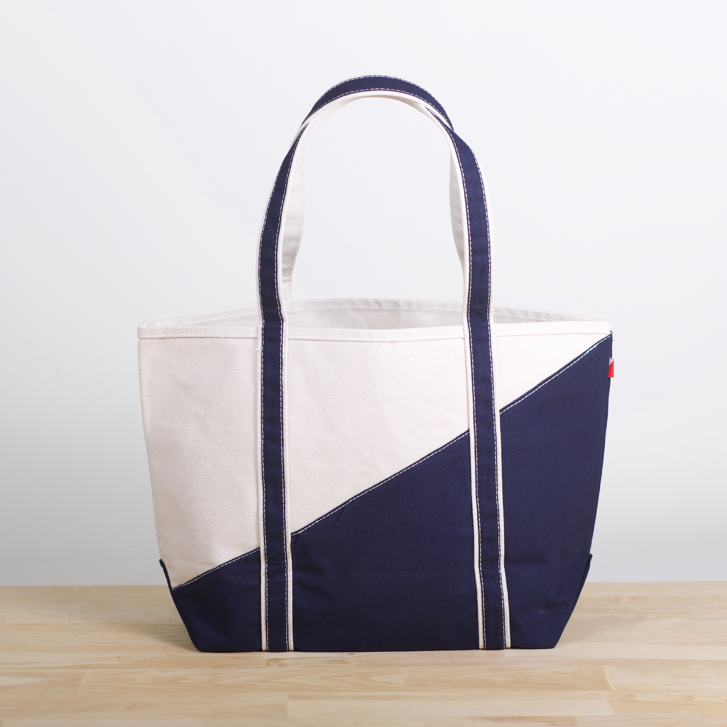 Navy and white tote bag on a wooden surface with a light gray background