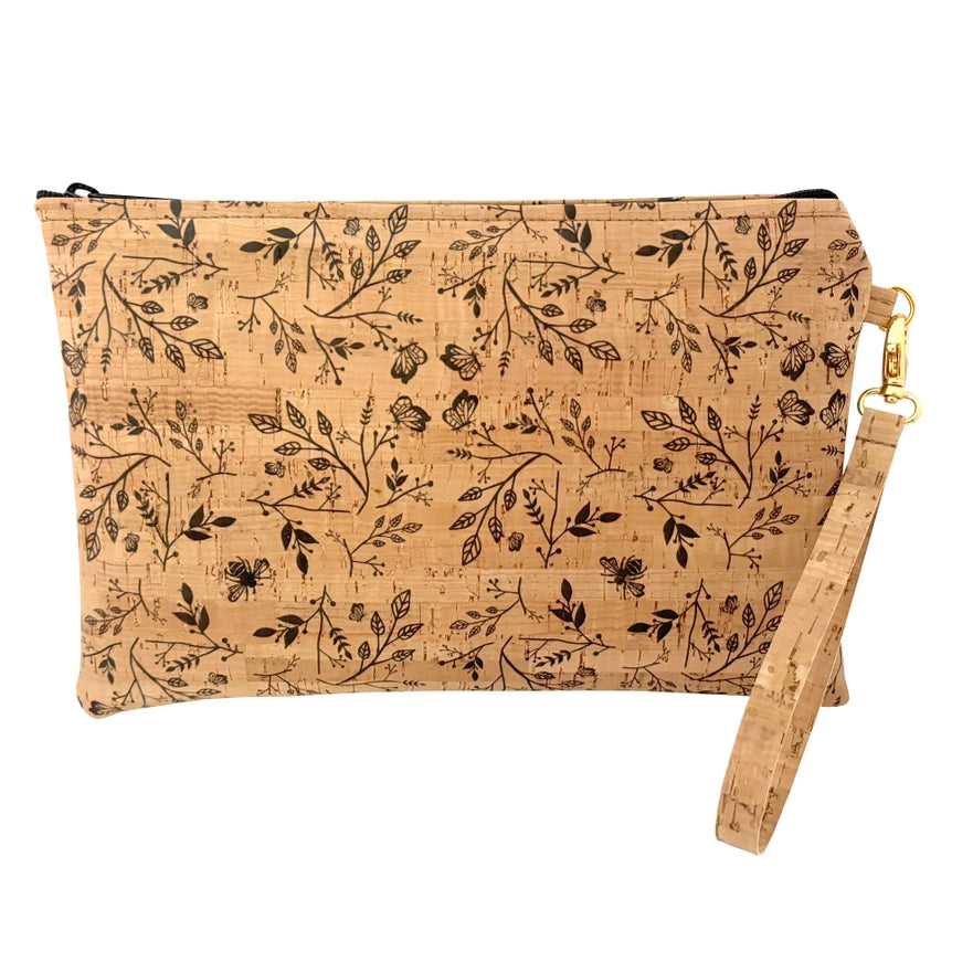 A beige cork wristlet with black floral print and a wrist strap, zipper closure, and a zipper pull.