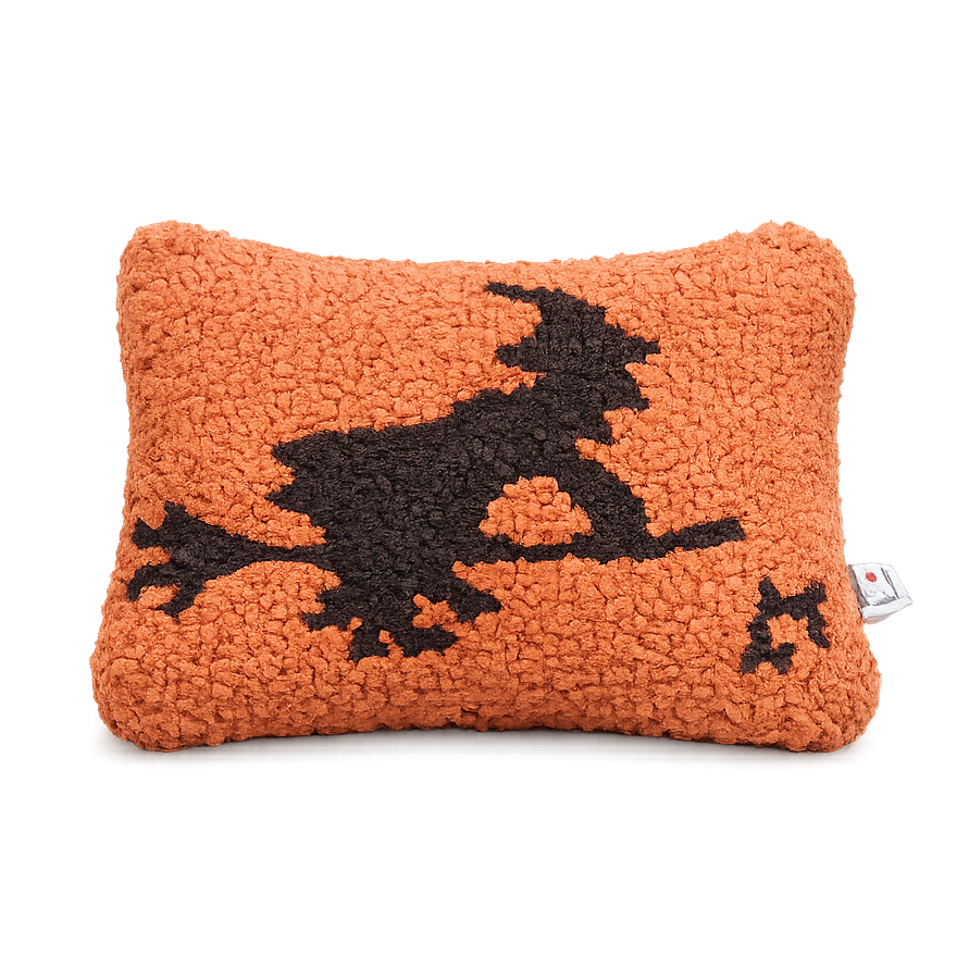 Orange pillow with a black witch design on a white background