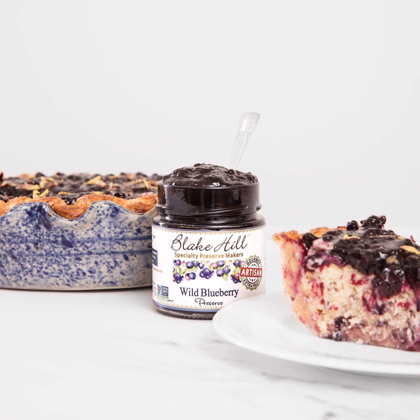 Jar of Blake Hill Wild Blueberry Preserves with a pie and slice of pie in the background
