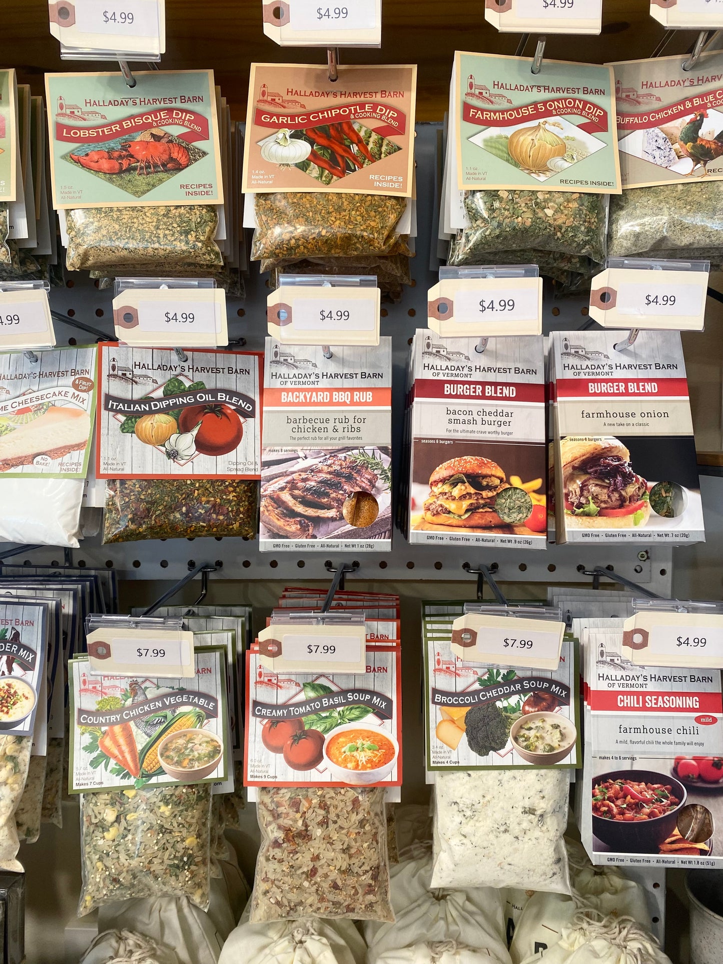 Display of various food product packages on a shelf with price tags.