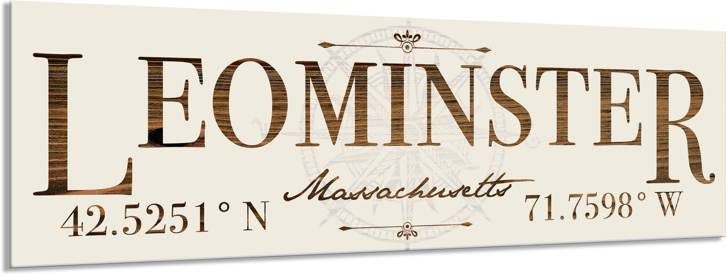 Decorative sign with 'Leominster, Massachusetts' text and coordinates on a beige background