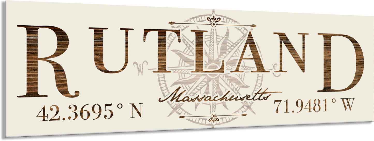 Decorative sign with 'Rutland, Massachusetts' text and coordinates on a beige background