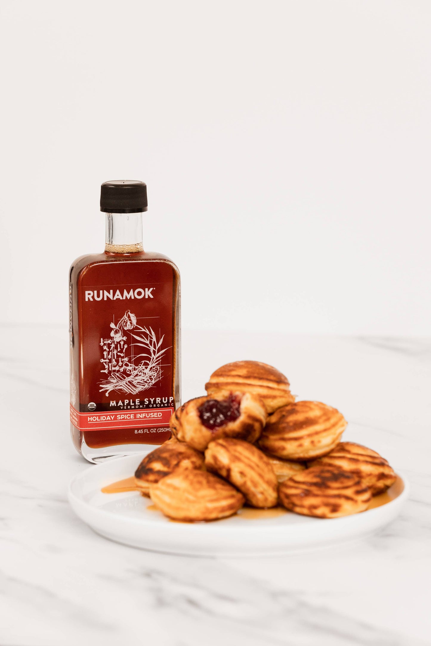 Runamok maple syrup bottle with baked goods on a white background