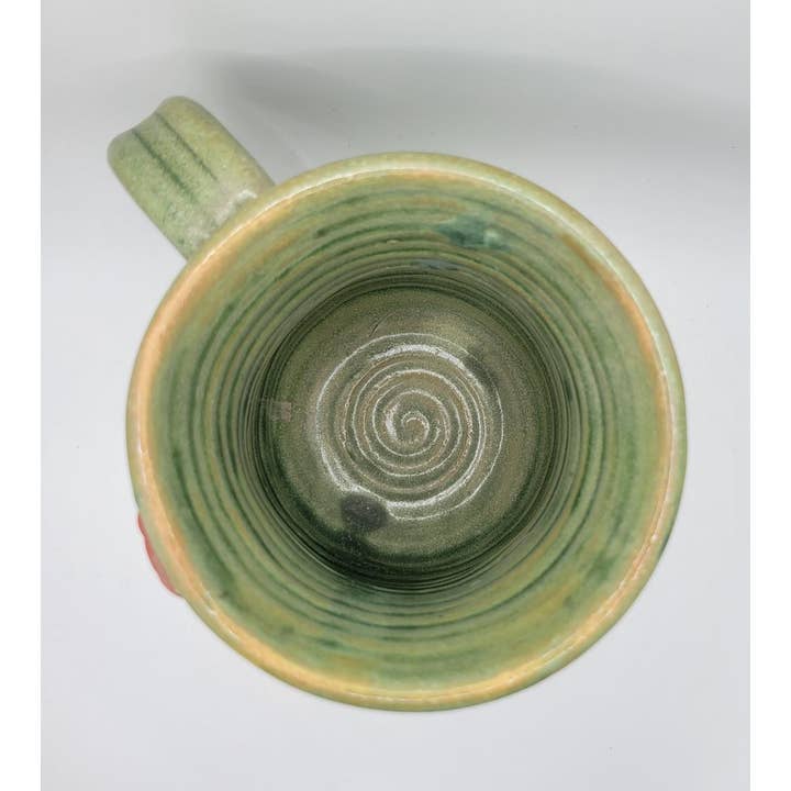 Green ceramic mug with a spiral design on a white background