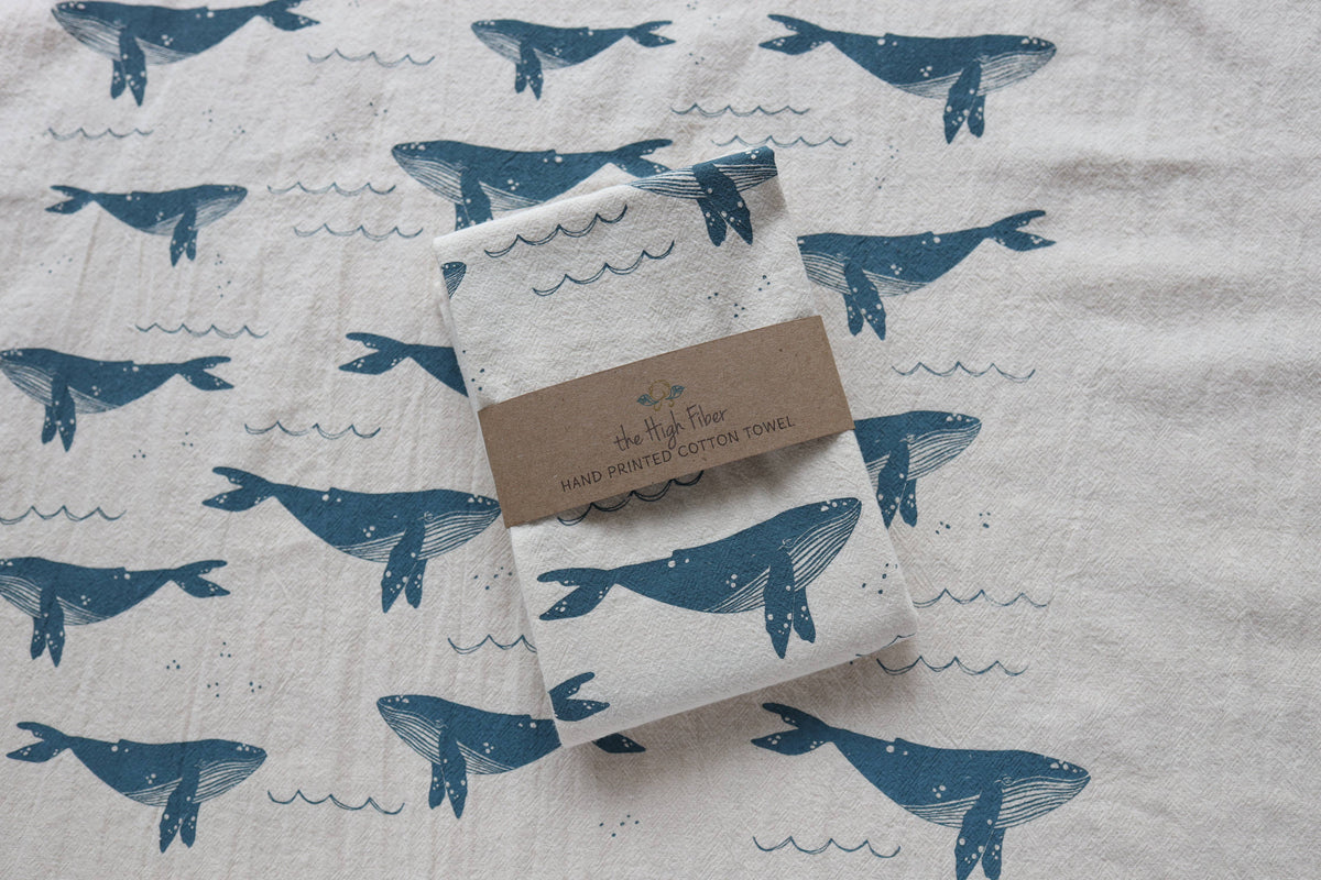 Folded towel with whale pattern on a fabric background