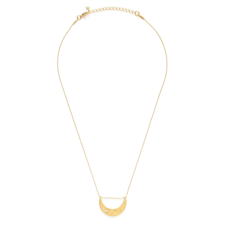 Gold necklace with a half moon pendant on a white background