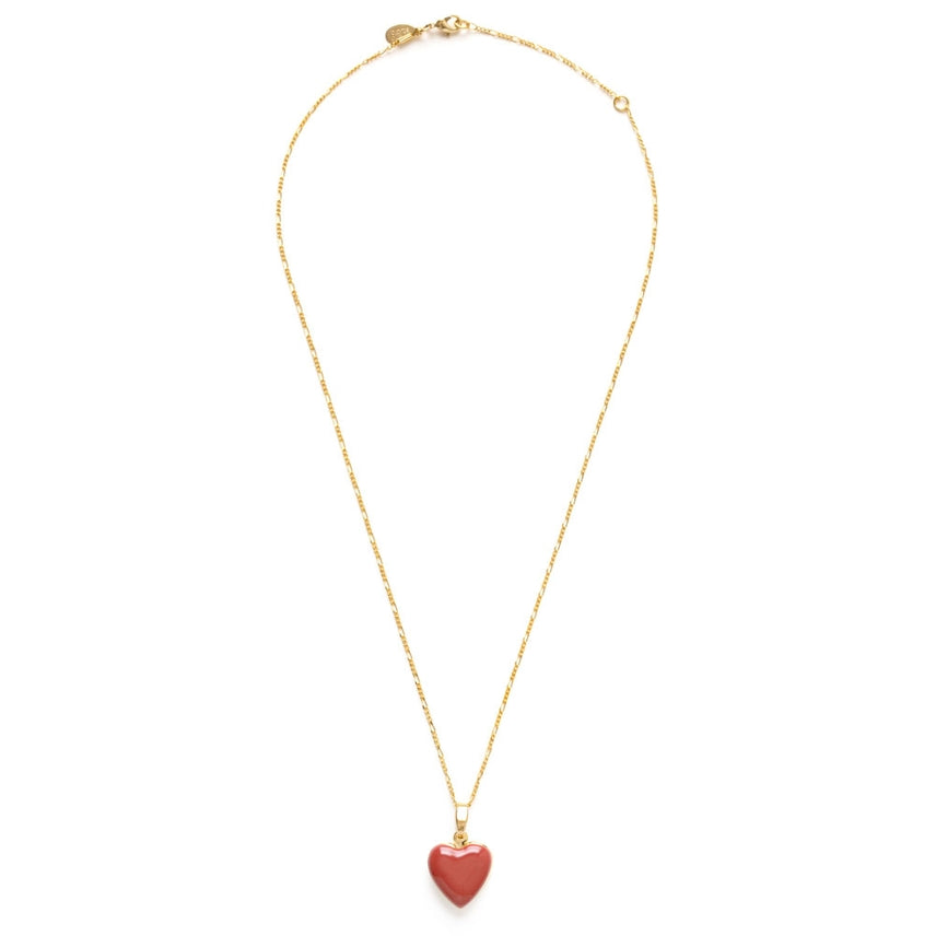 Gold necklace with a pink heart pendant on a white background