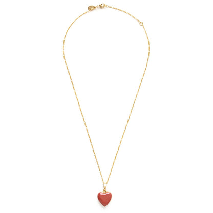 Gold necklace with a pink heart pendant on a white background