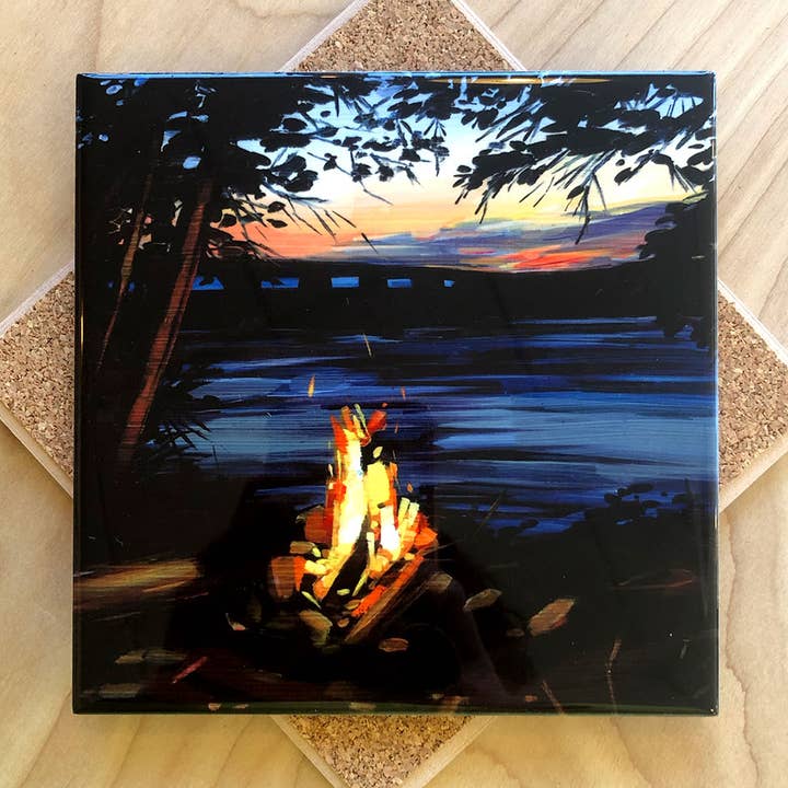 Trivet with a painting of a campfire by a lake with a sunset sky