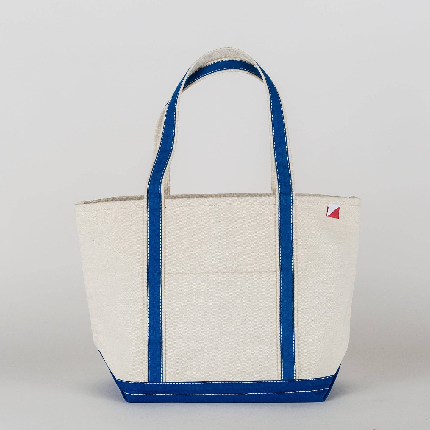 White tote bag with blue trim on a white background