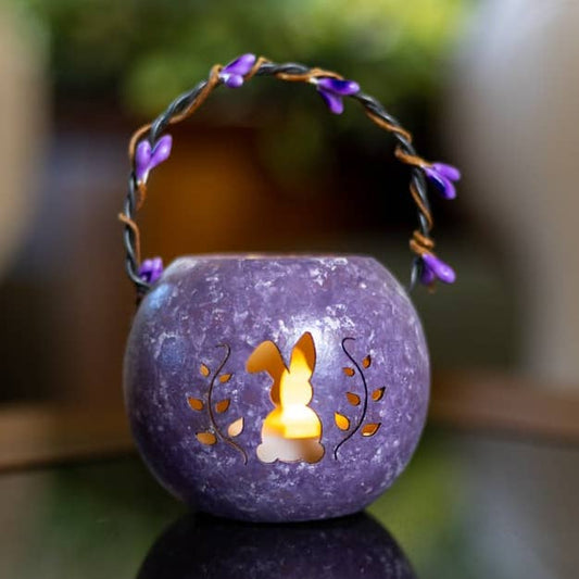 Decorative purple lantern with cut-out design on a blurred background