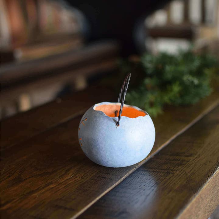 Decorative lantern with a lit candle inside on a wooden surface