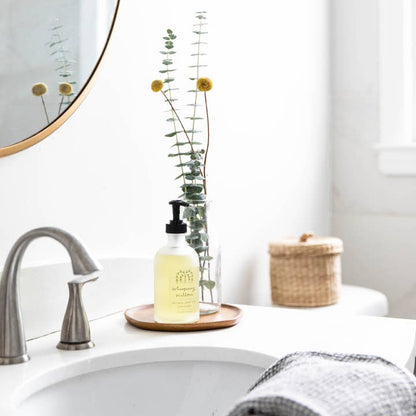 Bathroom counter with a bottle of soap, mirror, and towel