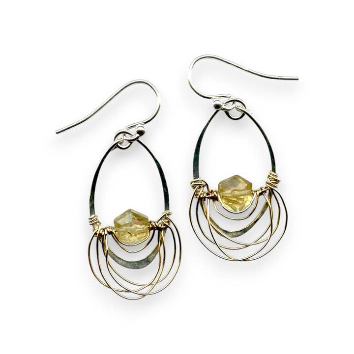 Pair of silver and gold hoop earrings with embedded stones on a white background
