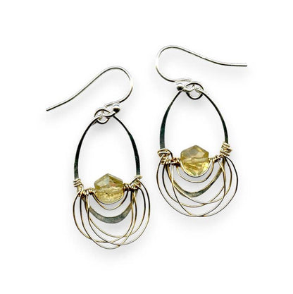 Pair of silver and gold hoop earrings with embedded stones on a white background