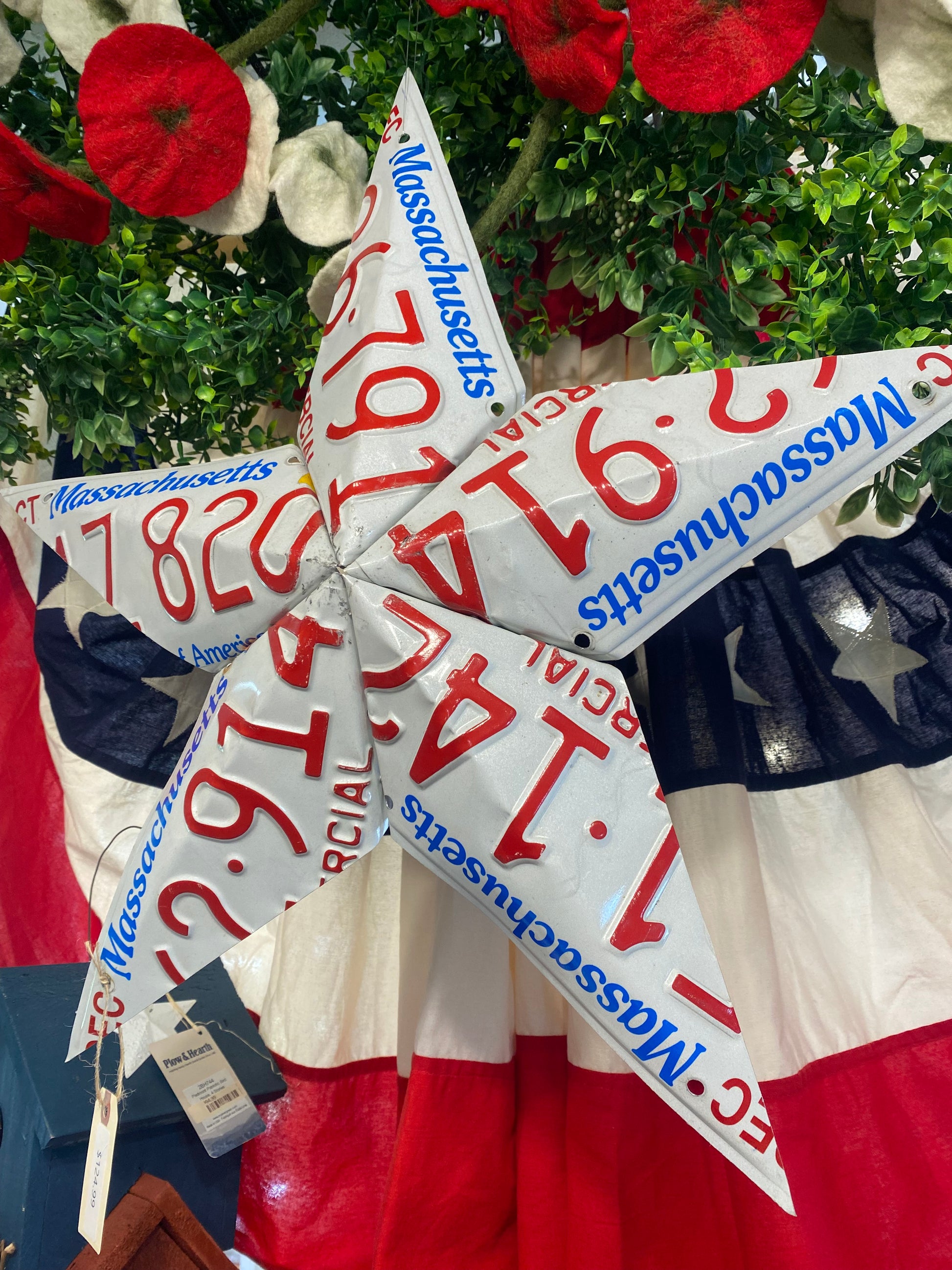 Massachusetts license plates arranged in a star shape with an American flag background.