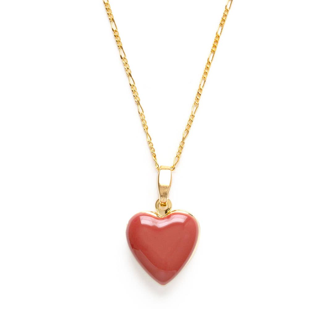 Gold necklace with a pink heart pendant on a white background