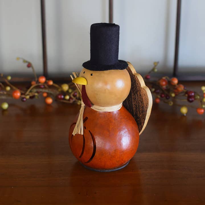 Decorative turkey with a top hat on a wooden surface with blurred background