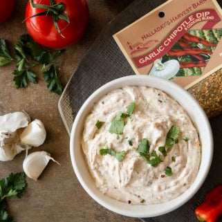 Garlic chipotle dip in a bowl with ingredients and a package on a rustic surface