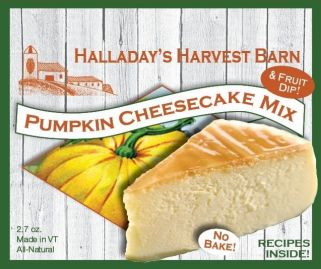 Pumpkin cheesecake mix packaging with a slice of cheesecake and pumpkins on a wooden background.