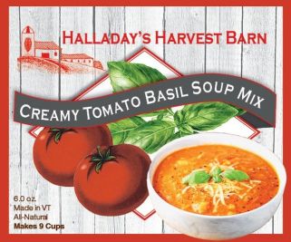Halladay's Harvest Barn Creamy Tomato Basil Soup Mix packaging with tomatoes and basil on a wooden background.