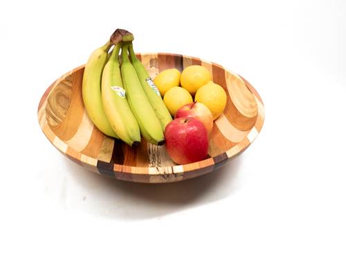 Wooden bowl with bananas, apples, and lemons on a white background
