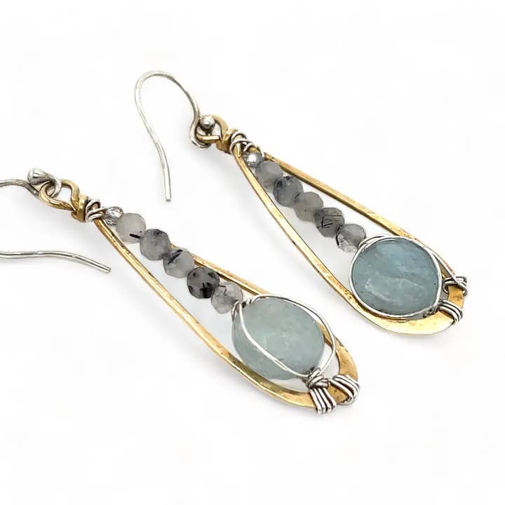 Pair of earrings with gold and silver accents and green stones on a white background