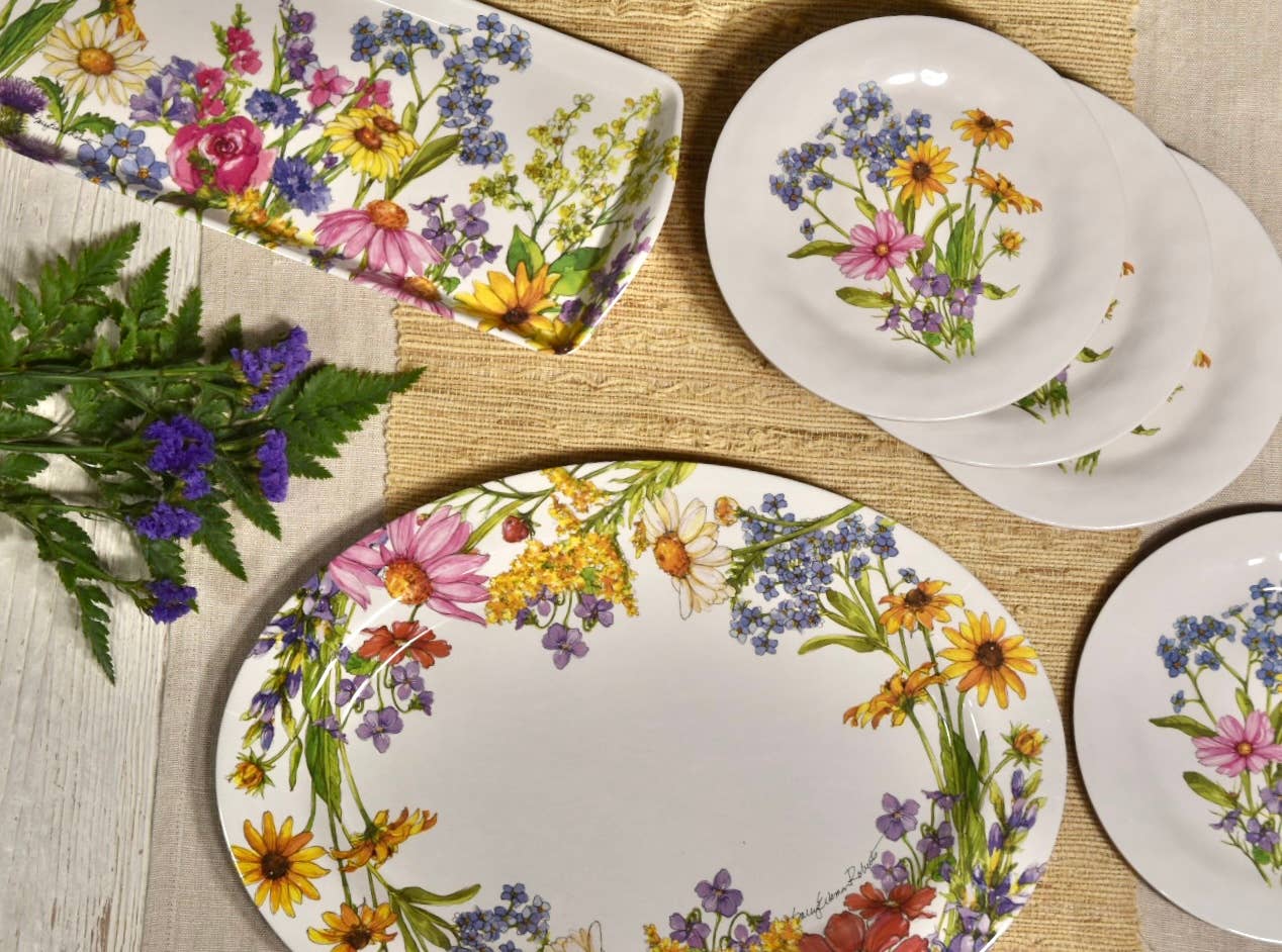 Set of plates with floral designs on a wooden surface.