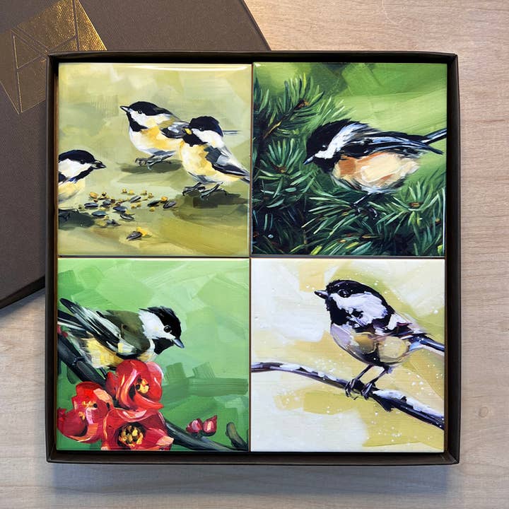 Set of four bird-themed tiles in a gift box on a wooden surface.