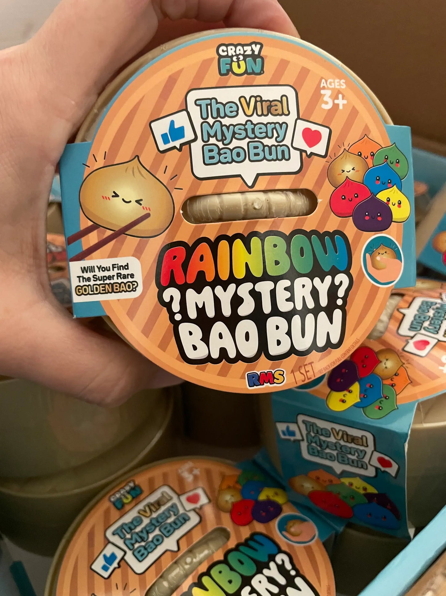 Hand holding a container of 'Rainbow Mystery Bao Bun' toy by Crazy Fun.