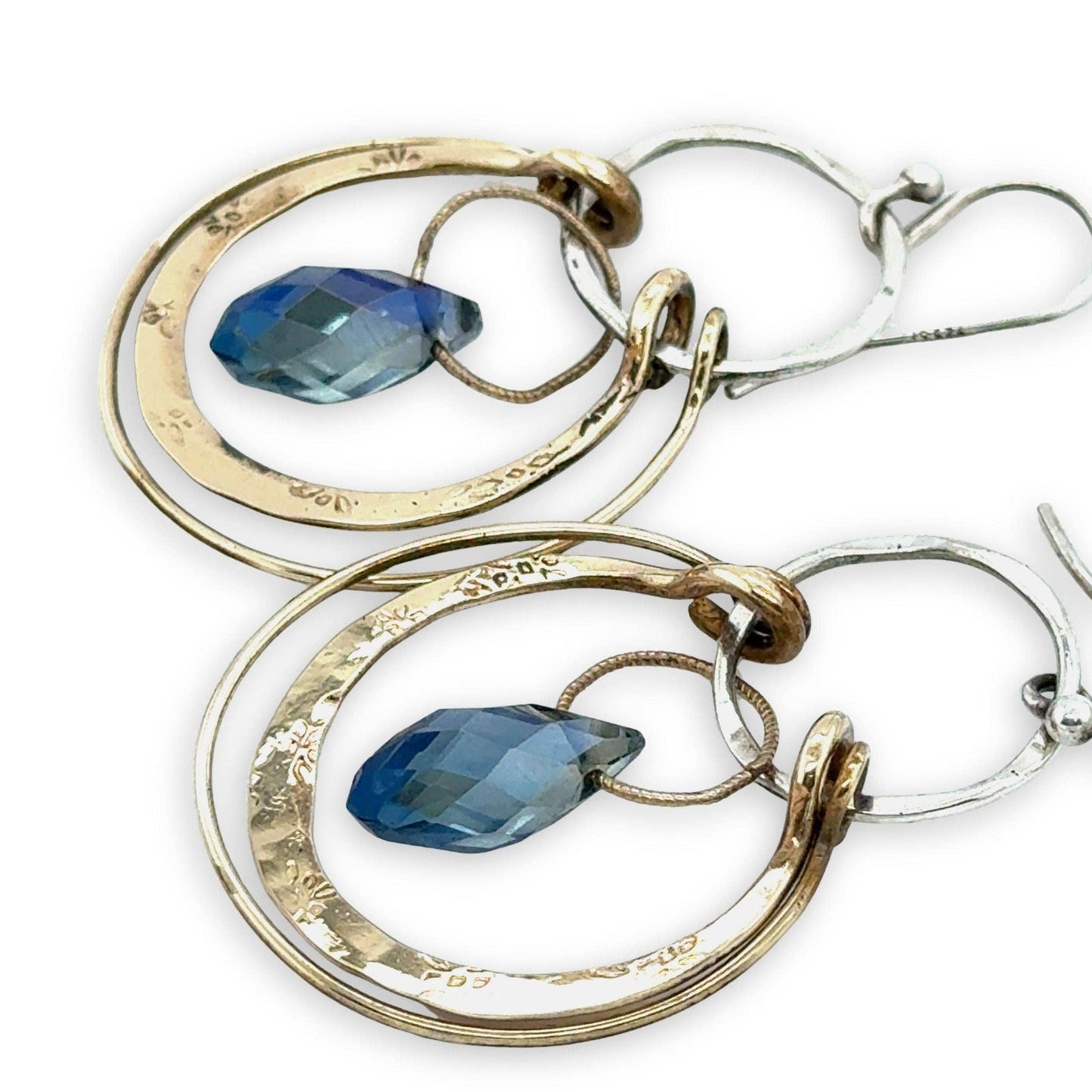 Pair of hoop earrings with blue gemstones on a white background