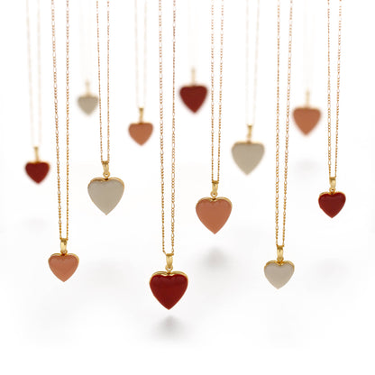 Heart-shaped pendants on gold chains against a white background