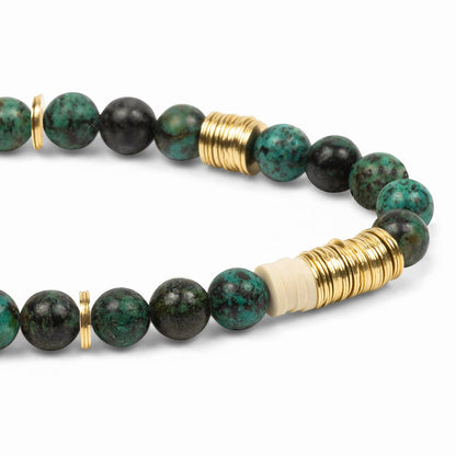 Beaded bracelet with green and black beads and gold accents on a white background
