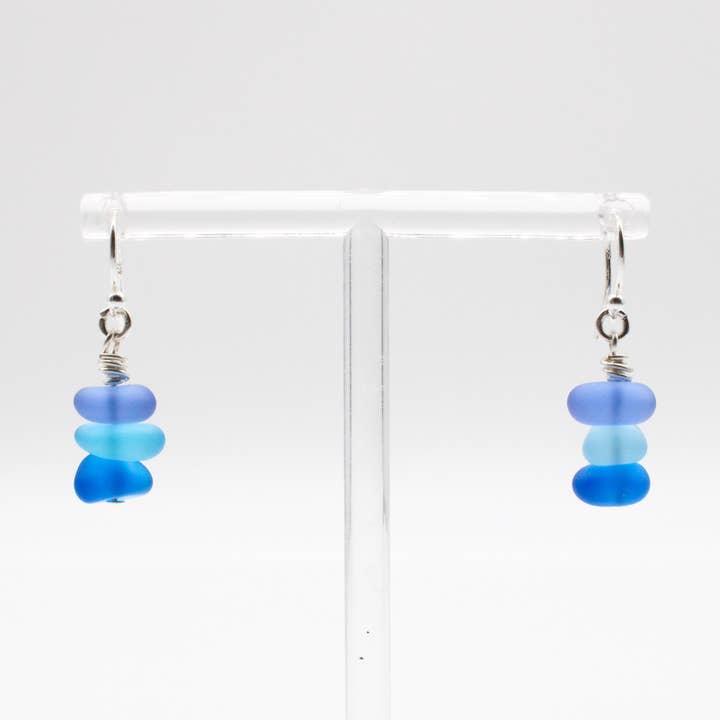 Pair of earrings with blue beads on a white background