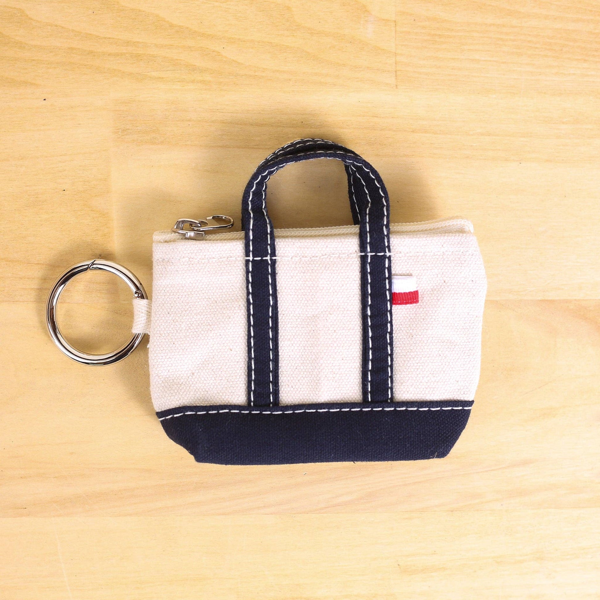 Small fabric bag with a keyring on a wooden surface