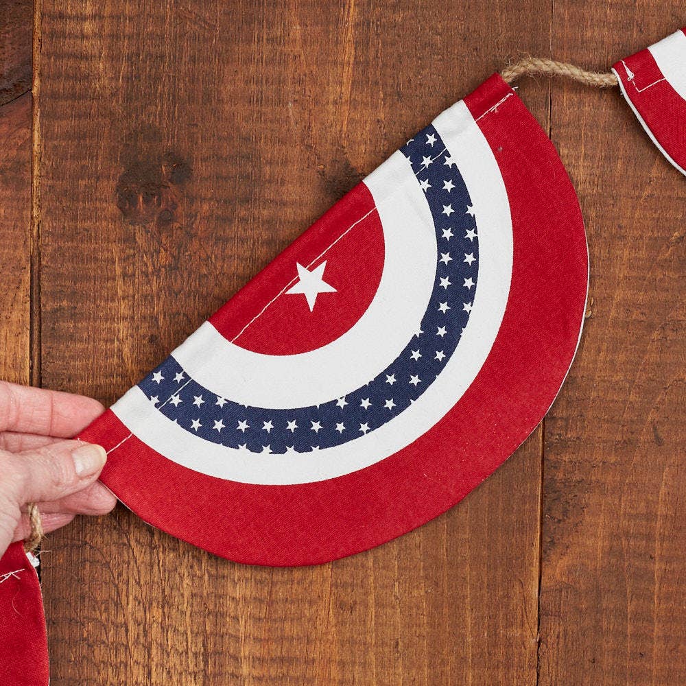 Red, white, and blue half-circle flag garland with a star on a wooden background
