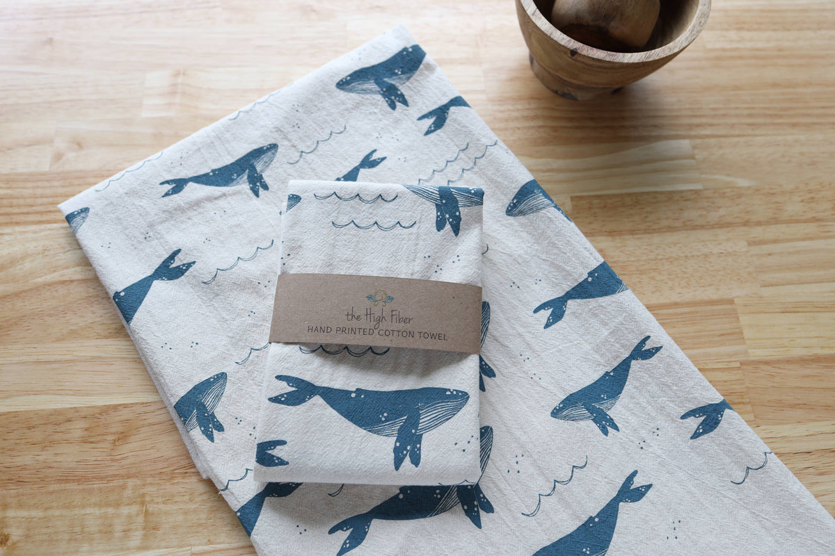 Folded towel with whale pattern on a wooden surface