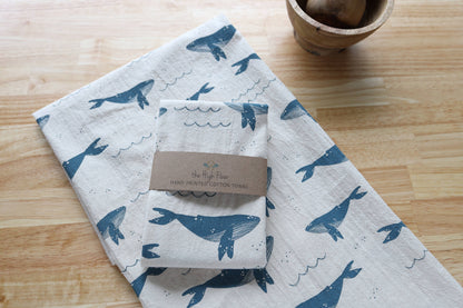 Folded towel with whale pattern on a wooden surface
