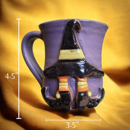 Ceramic mug with witch hat design and measurements on a yellow background. All images associated with this product listing show the same mug from various angles. The design is only on one side of the mug.