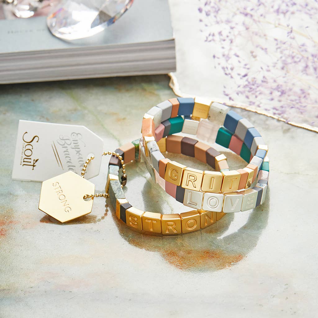 Colorful mosaic bracelet with gold accents on a textured surface
