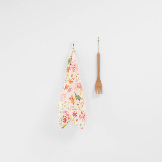 Floral kitchen towel and wooden fork on a white background