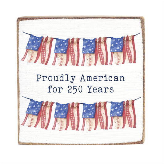 Decorative sign with American flags and text 'Proudly American for 250 Years' on a white background.