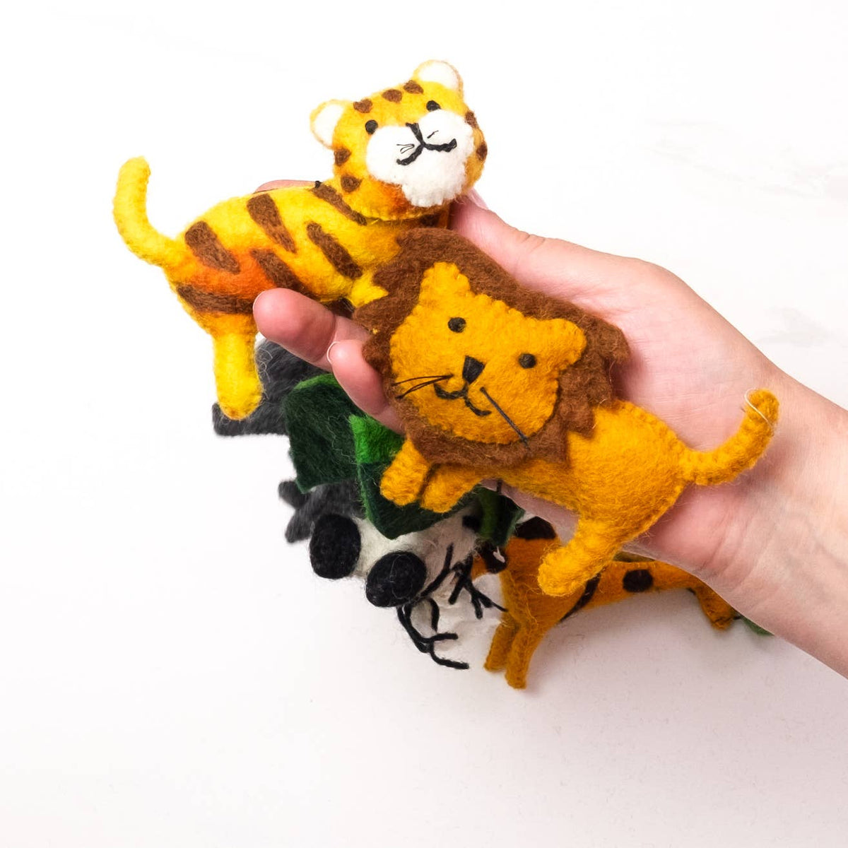 Hand holding felt animal garland including a lion, tiger, and giraffe on a white background.