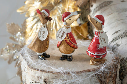 Three decorative duck figurines wearing Santa hats on a wooden base with a festive background.