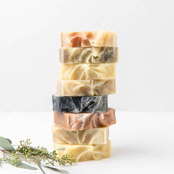 Stack of handmade soap bars with natural swirl patterns on a white background
