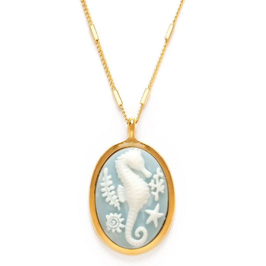 Gold necklace with a pendant featuring a white seahorse design on a white background.