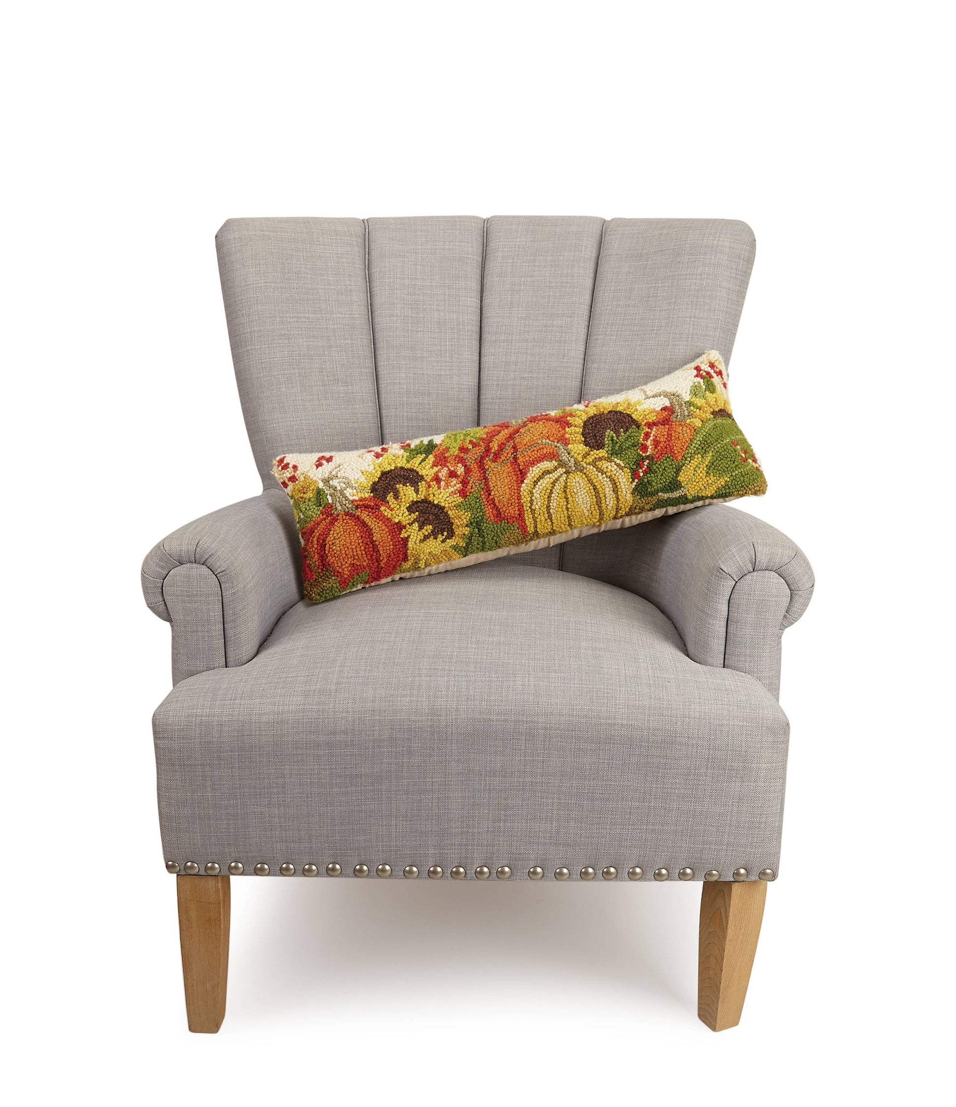 Gray armchair with a decorative pillow featuring pumpkins and sunflowers on a white background