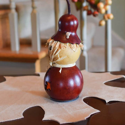 Decorative scarecrow gourd on a table with a blurred background
