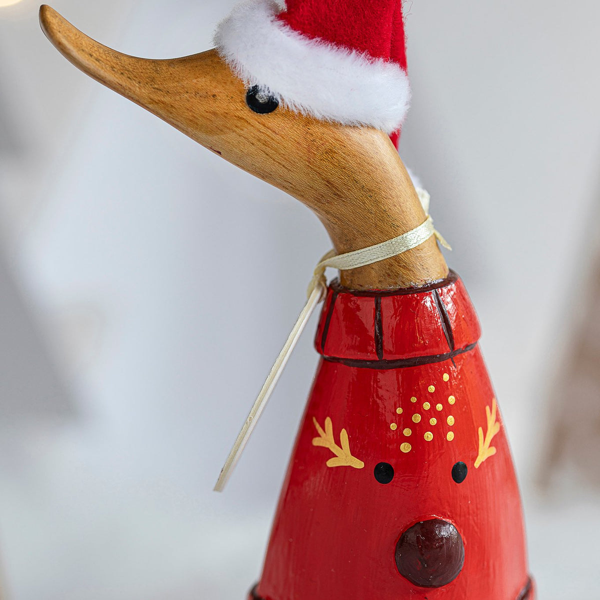 Decorative duck figurine wearing a Santa hat and red outfit on a white background